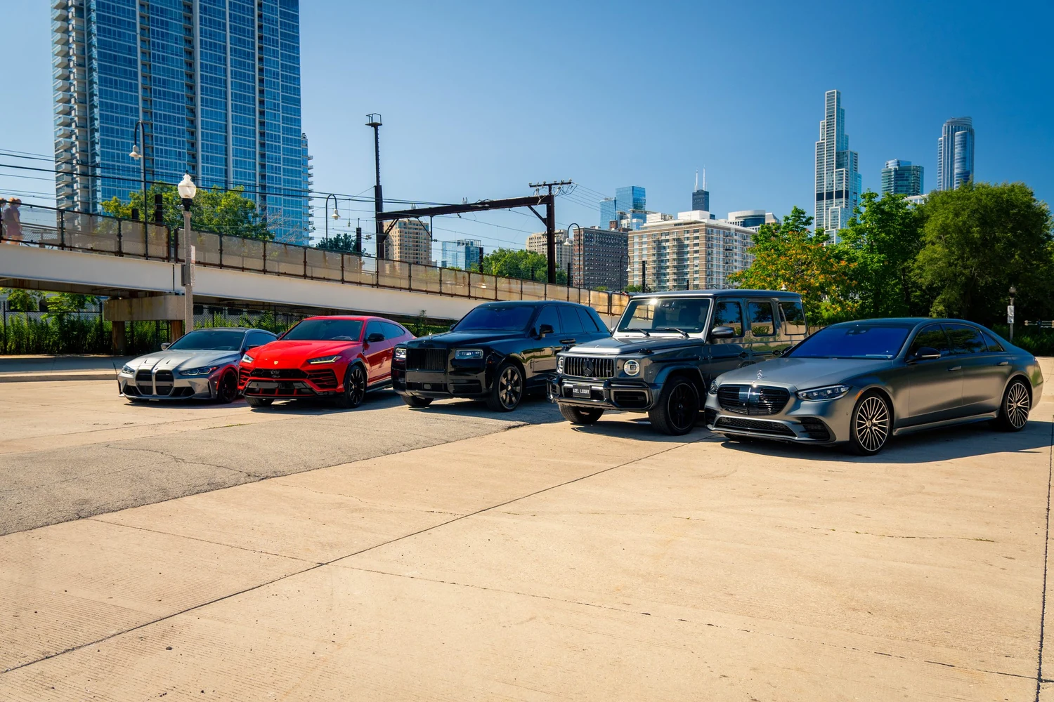 Axel Luxury fleet lineup — BMW M, Lamborghini Urus, Rolls-Royce Cullinan, Mercedes-AMG G63 and Mercedes S-Class — in front of the Chicago skyline